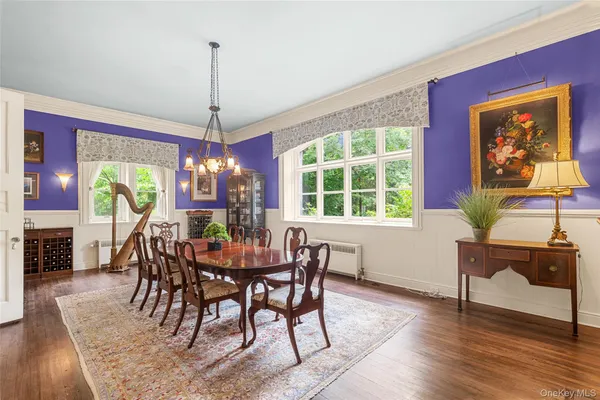 a dining room with furniture a chandelier and wooden floor