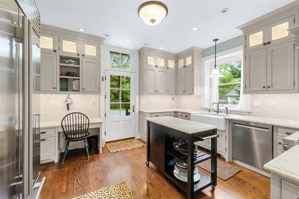 a kitchen with stainless steel appliances granite countertop a stove top oven a sink a dining table and chairs