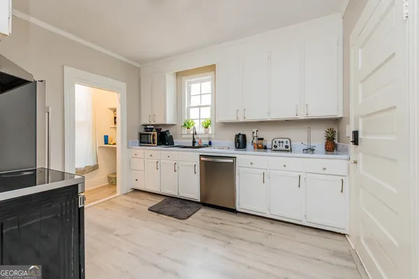 a kitchen with stainless steel appliances a sink cabinets and a window