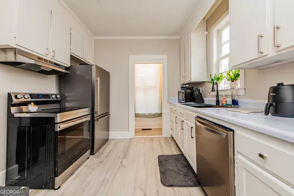 a kitchen with a sink stove and cabinets