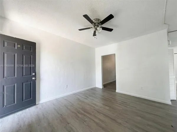 a view of a livingroom with wooden floor and a ceiling fan