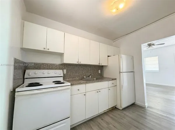 a kitchen with cabinets appliances a sink and a counter space