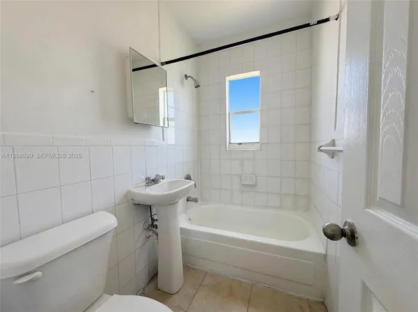 a bathroom with a sink and bathtub with toilet