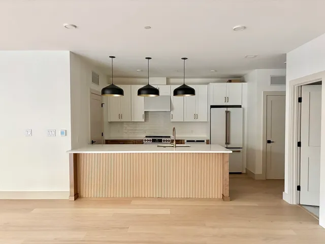 a kitchen with stainless steel appliances granite countertop a stove and a refrigerator