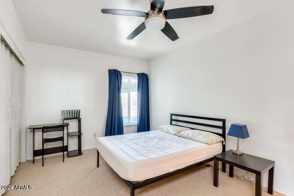 525 North May, Unit 10 Mesa, AZ 85201 - Photo 11 of 21 a bedroom with a bed and a chandelier