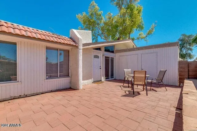 a backyard of a house with table and chairs