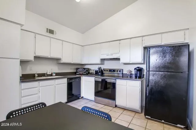 a kitchen with stainless steel appliances granite countertop a stove a refrigerator and a sink