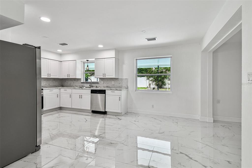 6016 Arthur Avenue New Port Richey, FL 34653 - Photo 16 of 33 a kitchen with a stove a sink dishwasher a refrigerator and cabinets