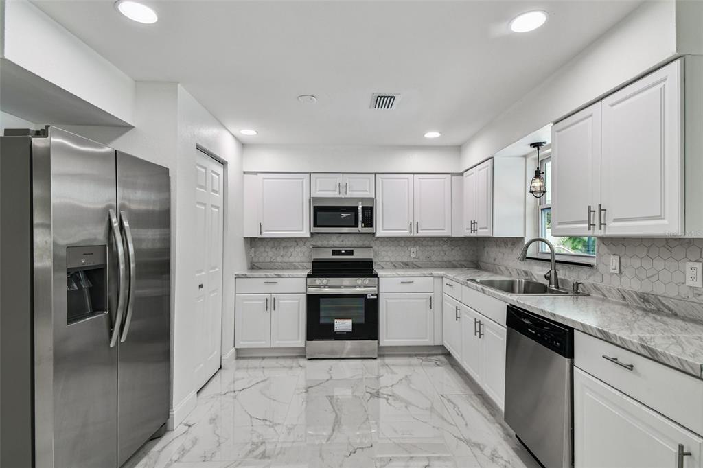 6016 Arthur Avenue New Port Richey, FL 34653 - Photo 20 of 33 a kitchen with stainless steel appliances granite countertop a refrigerator sink and cabinets