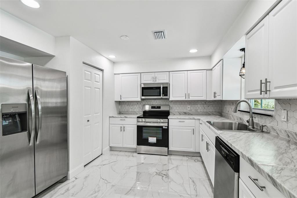 6016 Arthur Avenue New Port Richey, FL 34653 - Photo 21 of 33 a kitchen with a sink stainless steel appliances and cabinets