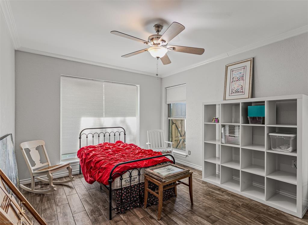3713 Hickox Road Rowlett, TX 75089 - Photo 22 of 36 a bedroom with a bed a dresser and book shelf