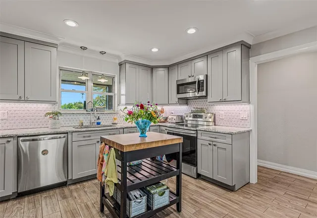 a kitchen with a dining table chairs cabinets and stainless steel appliances
