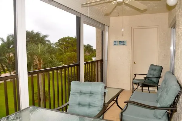 a balcony with wooden floor and outdoor seating