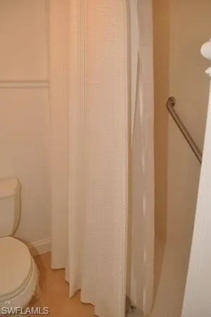 a white toilet sitting next to a shower curtain
