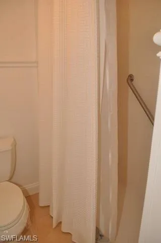 a white toilet sitting next to a shower curtain