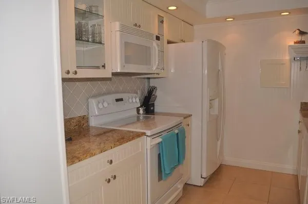 a kitchen with stainless steel appliances granite countertop a sink and a refrigerator