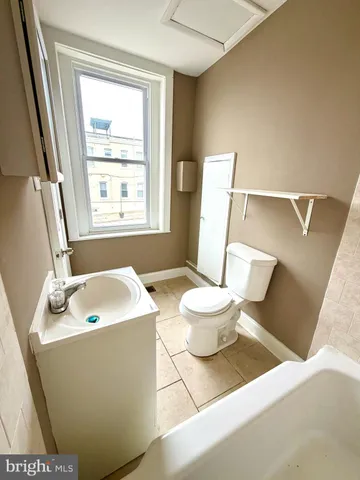 a bathroom with a sink a toilet a mirror and bathtub