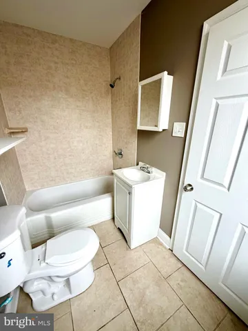 a white toilet sitting next to a bathroom sink and vanity