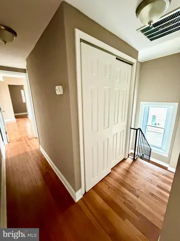 a view of a room with wooden floor and white walls