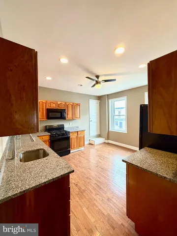 a living room with stainless steel appliances furniture and a kitchen view