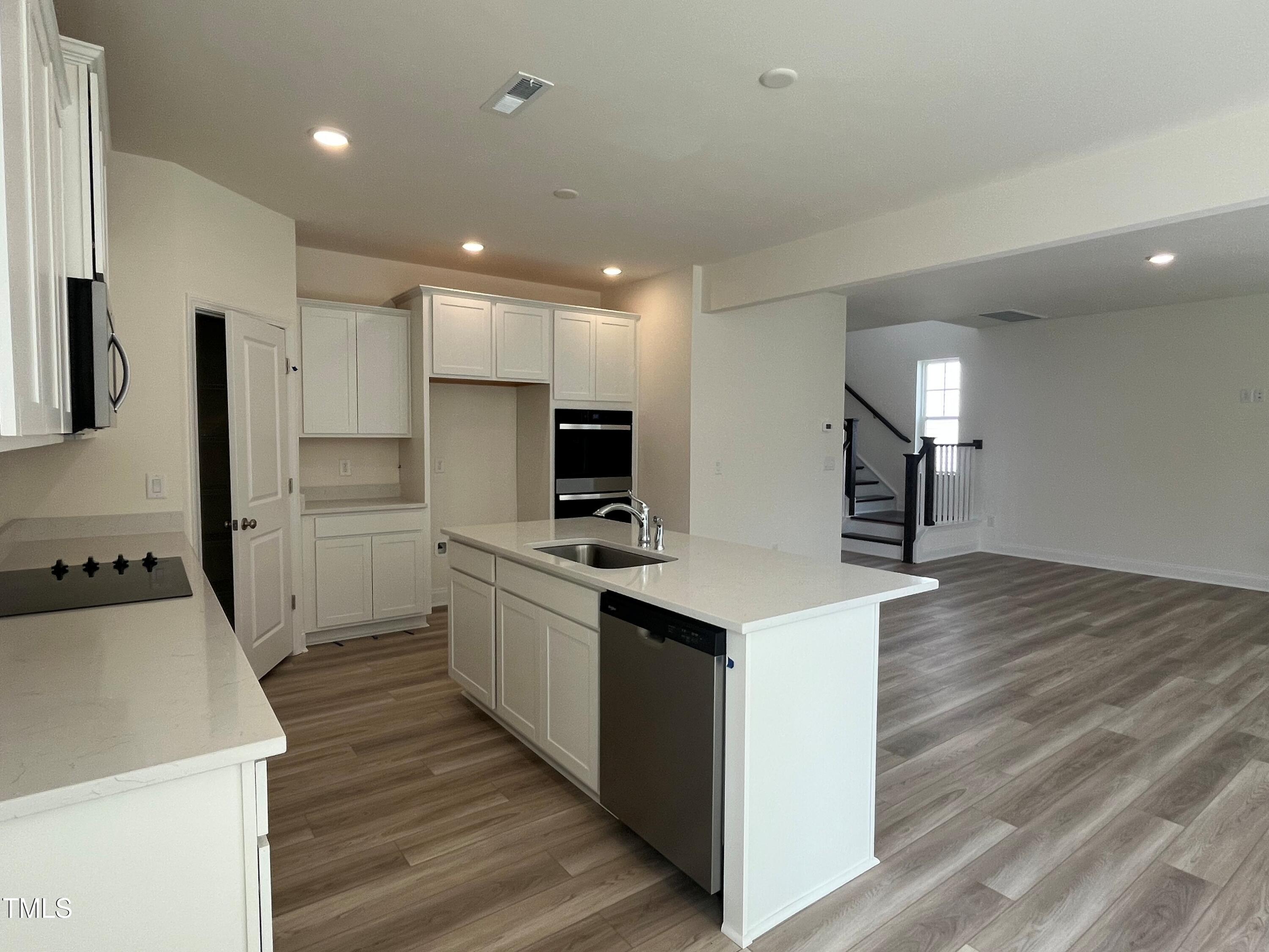 5108 River Sand Trail Raleigh, NC 27604 - Photo 21 of 59 a kitchen with white cabinets and stainless steel appliances