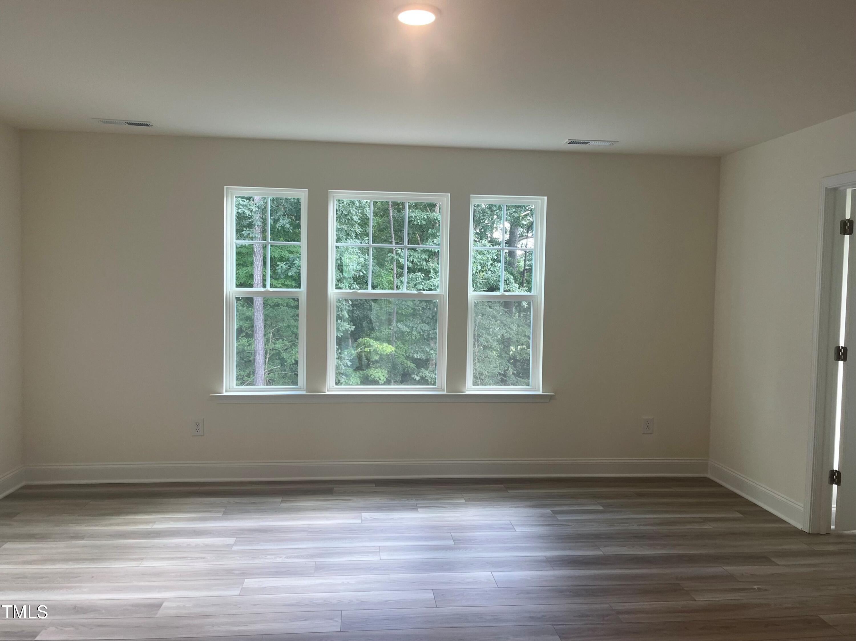 5108 River Sand Trail Raleigh, NC 27604 - Photo 40 of 59 a view of an empty room with wooden floor and a window
