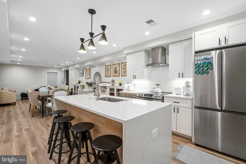 a kitchen with kitchen island a stove a table and chairs in it