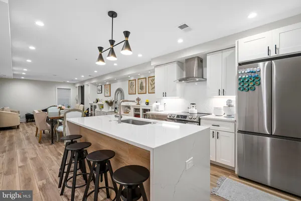 a kitchen with kitchen island a stove a table and chairs in it