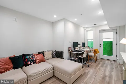 a living room with furniture and a wooden floor