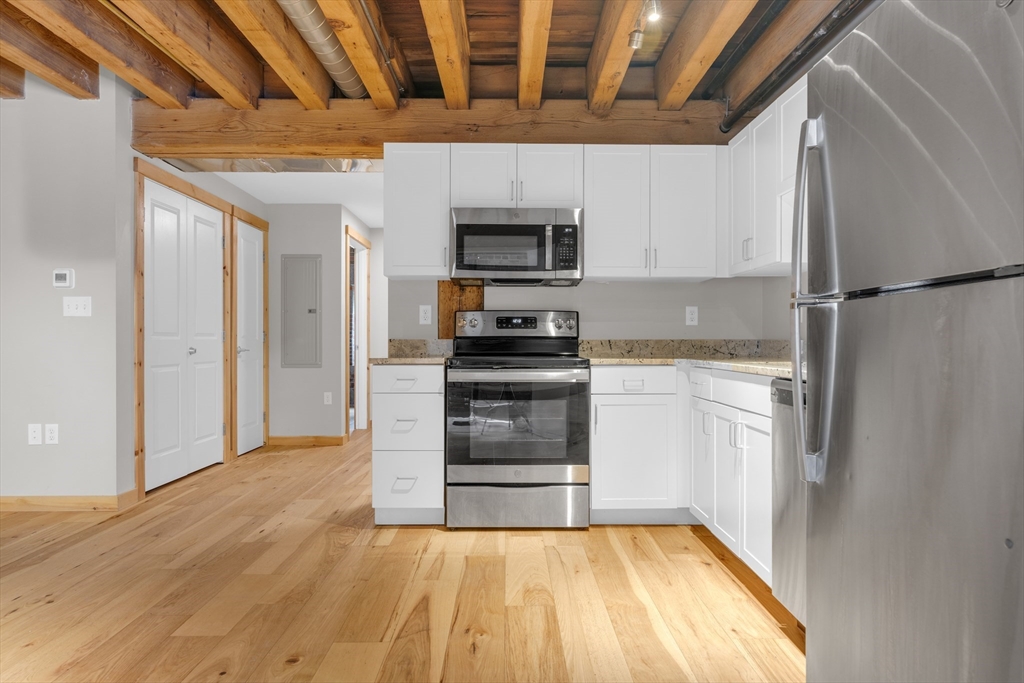 58 13th Street, Unit 112 Boston, MA 02129 - Photo 4 of 11 a kitchen with a refrigerator and a stove