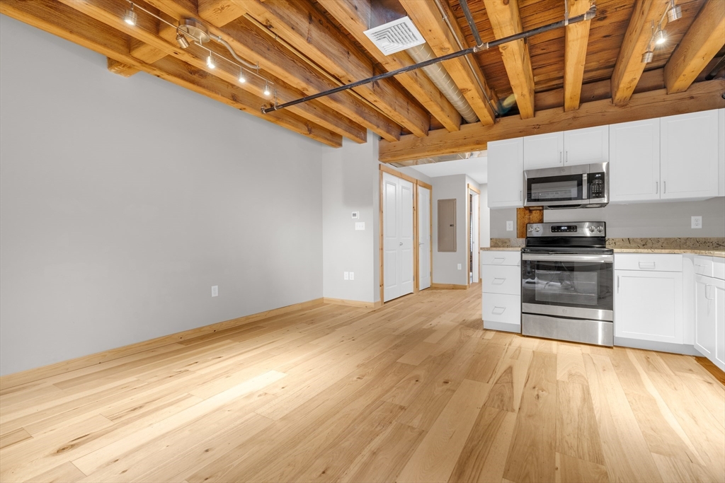 58 13th Street, Unit 112 Boston, MA 02129 - Photo 5 of 11 a view of a kitchen with a sink and a stove top oven