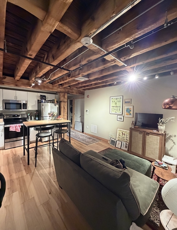 58 13th Street, Unit 112 Boston, MA 02129 - Photo 7 of 11 a living room with furniture and a wooden floor