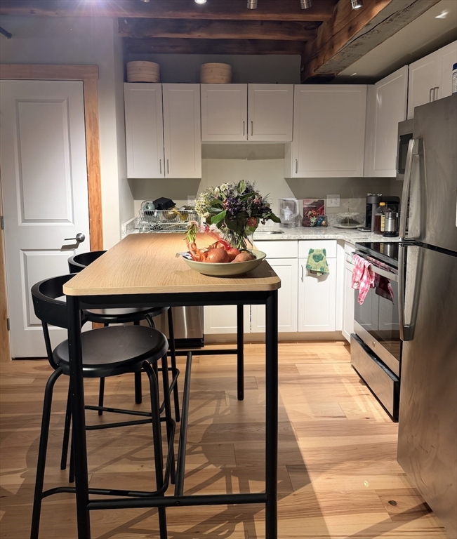 58 13th Street, Unit 112 Boston, MA 02129 - Photo 8 of 11 a room with a table chairs and a refrigerator