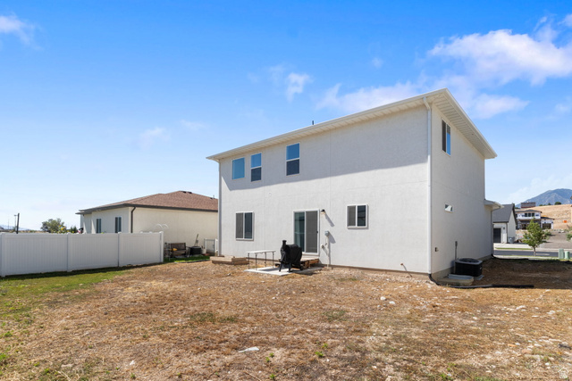 815 West Powderwood Lane Mapleton, UT 84664 - Photo 31 of 34 Rear exterior featuring a sliding glass door, a concrete patio, white stucco siding, and a white vinyl privacy fence