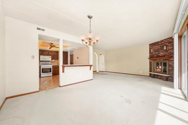 a view of a kitchen with fridge and wooden floor