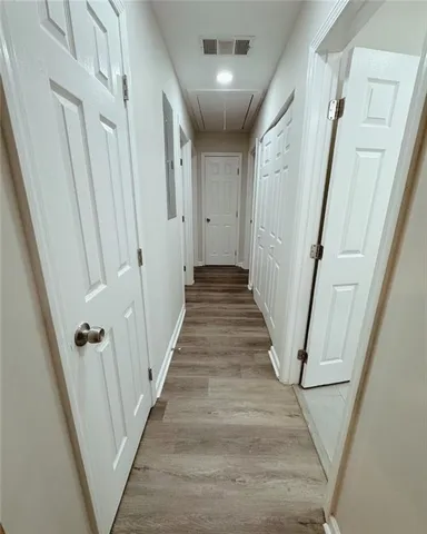 a view of a hallway with wooden floor and staircase