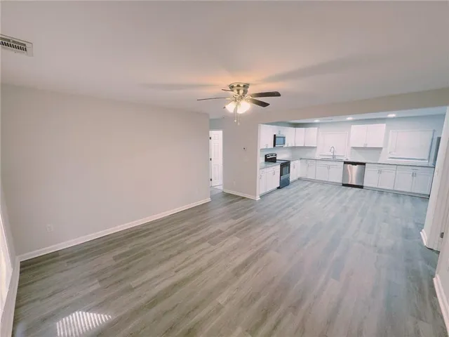 a view of a kitchen with a dishwasher cabinets and wooden floor