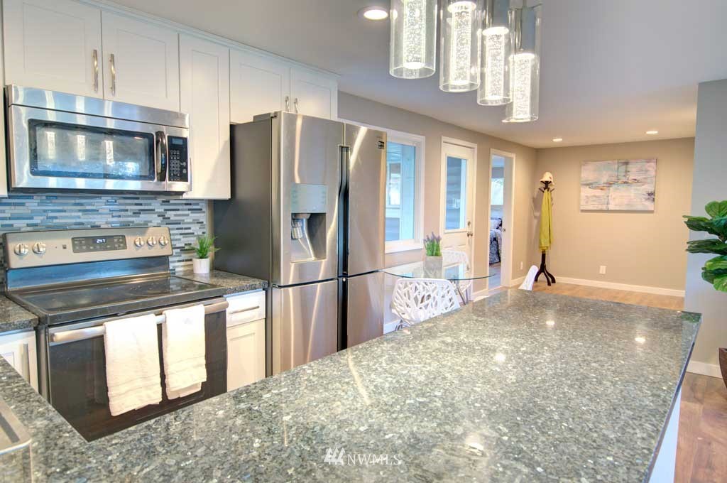 866 Queen Avenue Northeast Renton, WA 98056 - Photo 4 of 15 a kitchen with stainless steel appliances granite countertop a refrigerator a stove and a sink with cabinets
