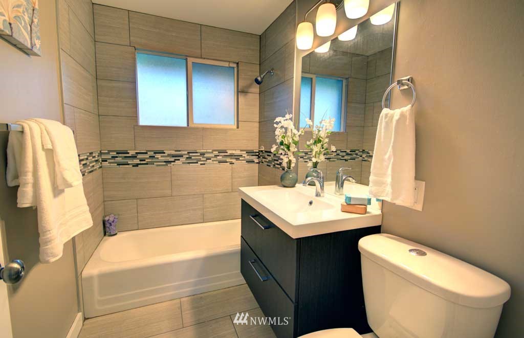 866 Queen Avenue Northeast Renton, WA 98056 - Photo 6 of 15 a bathroom with a sink a toilet a mirror and bathtub