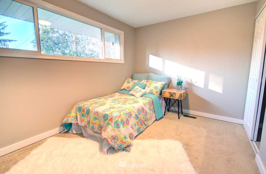 866 Queen Avenue Northeast Renton, WA 98056 - Photo 9 of 15 a bed sitting in a bedroom next to a window