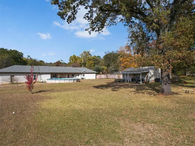 a view of a big house with a big yard and large tree