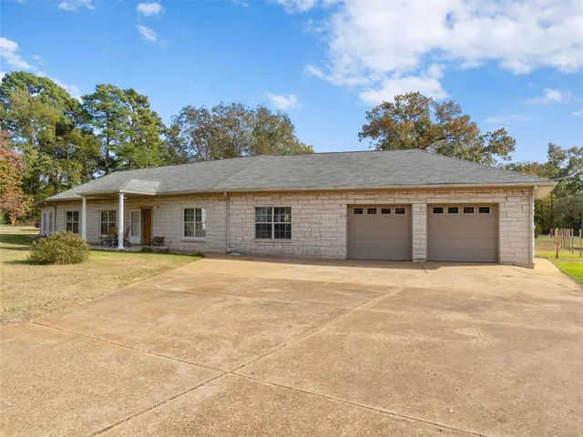 front view of a house with a big yard and large trees