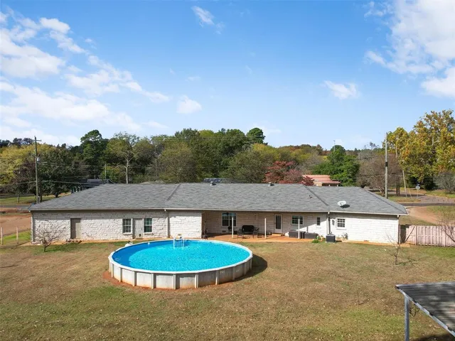a view of a house with pool and a yard