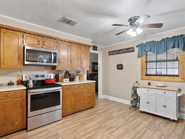 a kitchen with stainless steel appliances a stove refrigerator sink and microwave