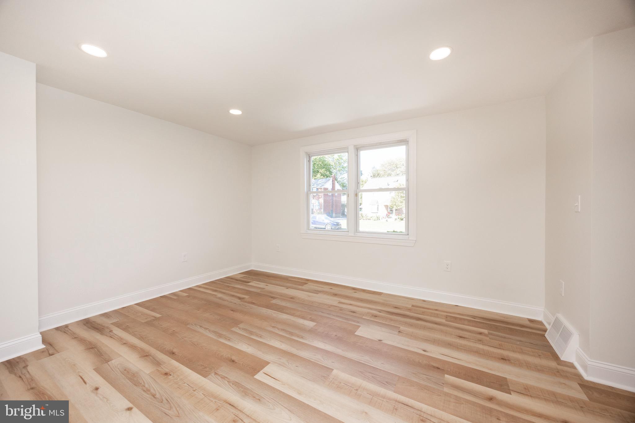 428 Adair Road Holmes, PA 19043 - Photo 13 of 59 an empty room with wooden floor and windows