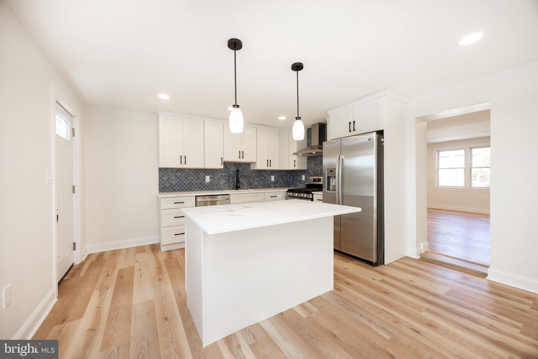 428 Adair Road Holmes, PA 19043 - Photo 14 of 59 a kitchen that has a sink a refrigerator a stove and a wooden floor