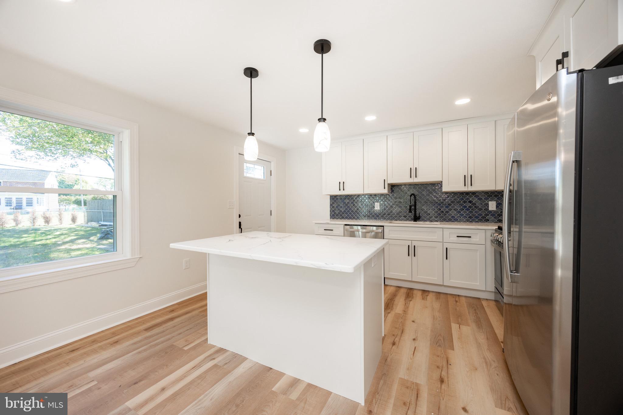 428 Adair Road Holmes, PA 19043 - Photo 15 of 59 a kitchen with stainless steel appliances granite countertop a sink a stove a refrigerator a center island with wooden floor and cabinets