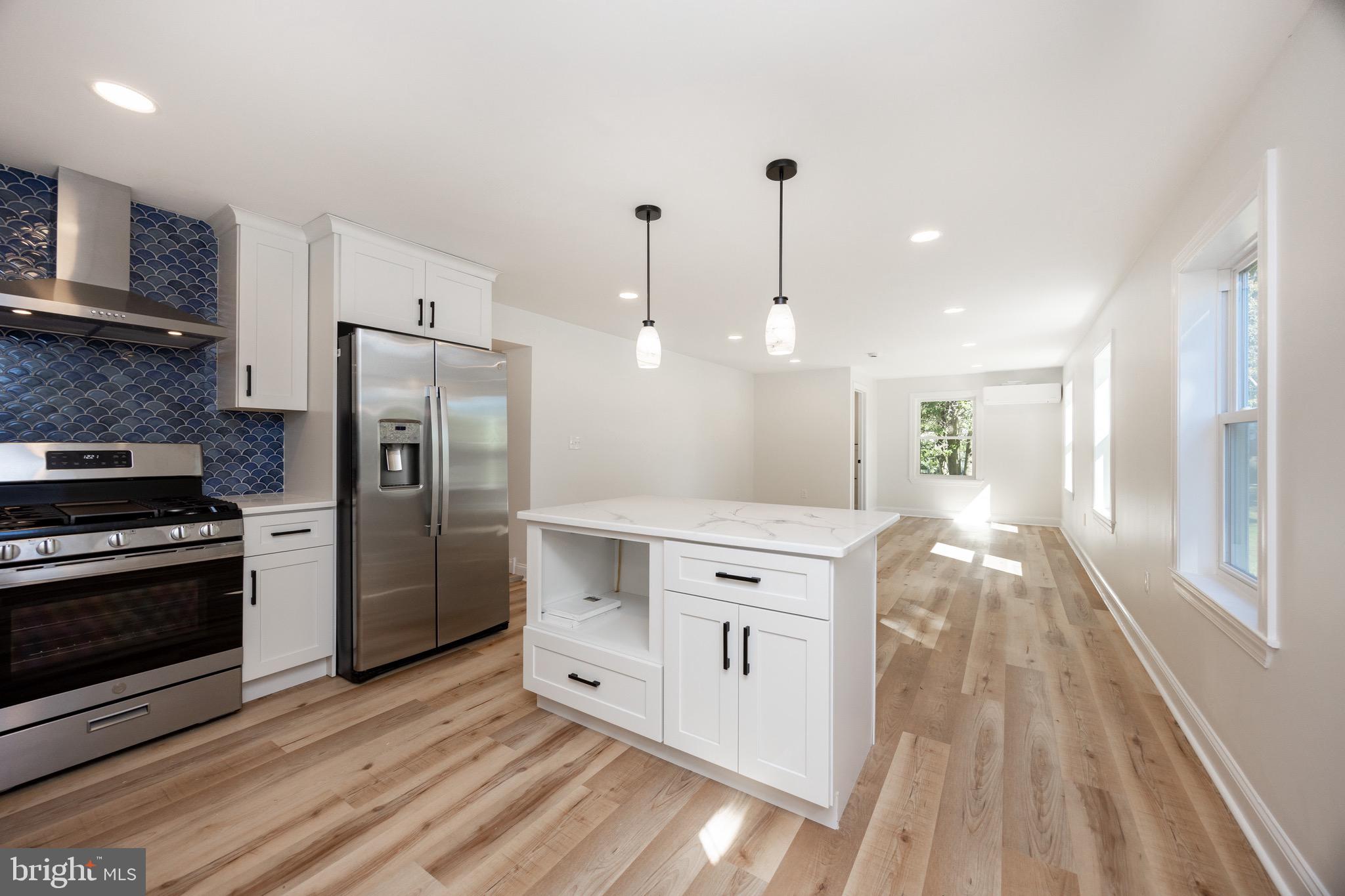 428 Adair Road Holmes, PA 19043 - Photo 16 of 59 a kitchen with stainless steel appliances granite countertop a refrigerator a stove and a wooden floors