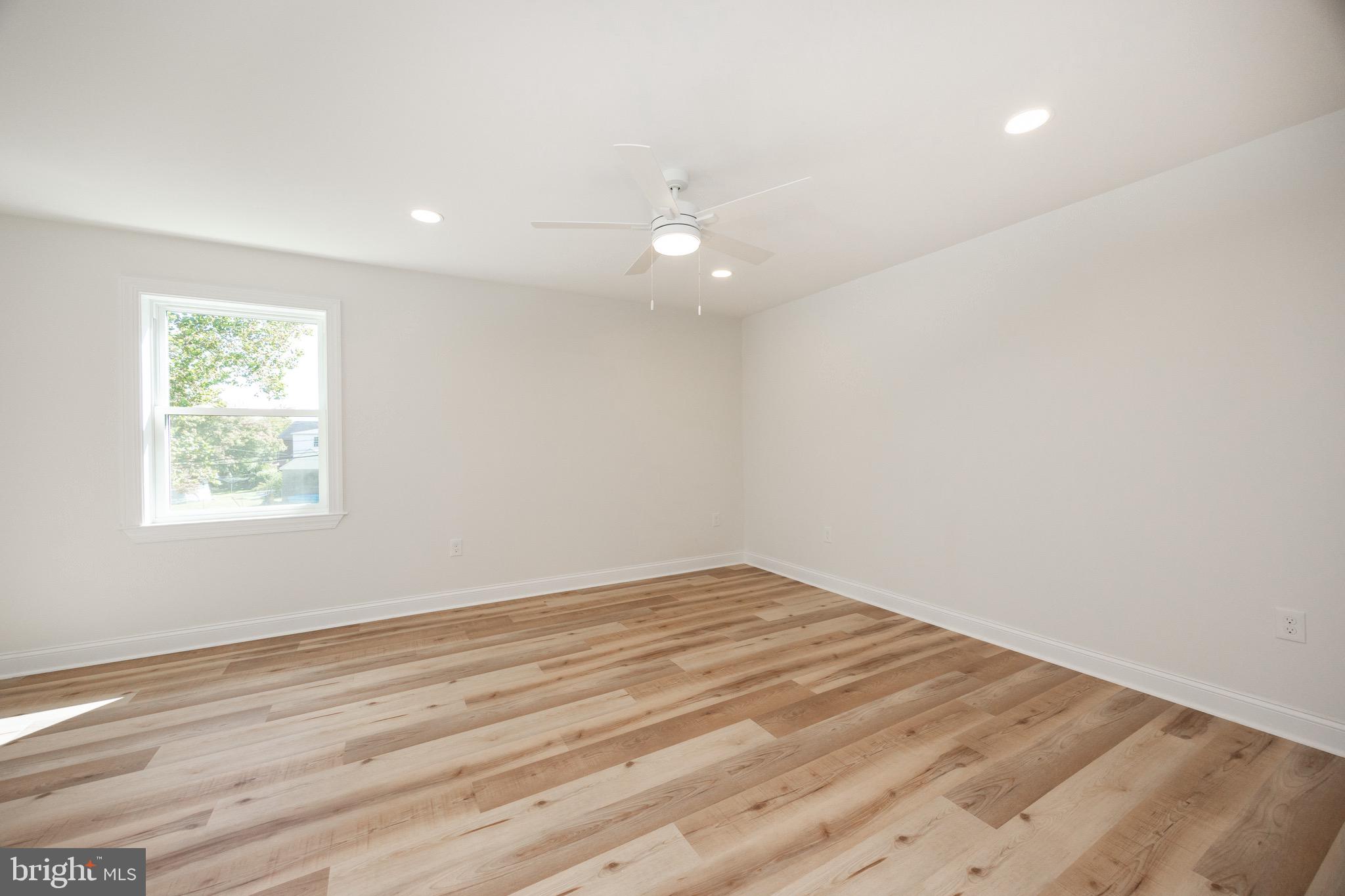 428 Adair Road Holmes, PA 19043 - Photo 25 of 59 an empty room with wooden floor and windows