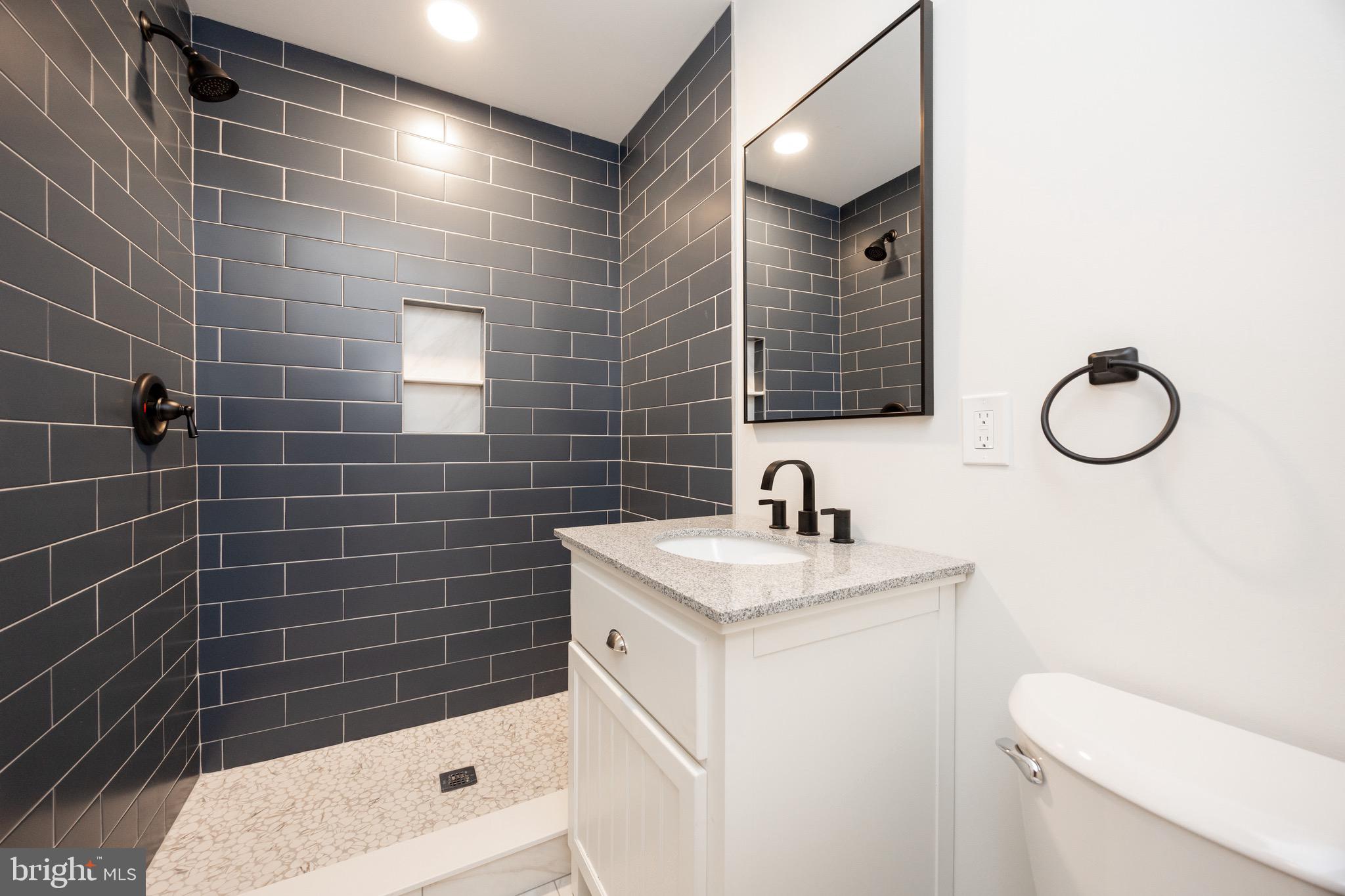428 Adair Road Holmes, PA 19043 - Photo 26 of 59 a bathroom with a sink a toilet a mirror and shower